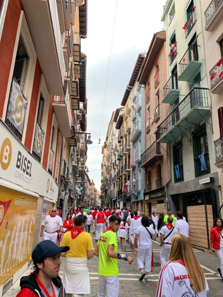 People walk the boarded up route that bulls race through the old city of Pamplona. This is moments after the bulls have arrived in the Arena for La fiesta de San Fermín.
