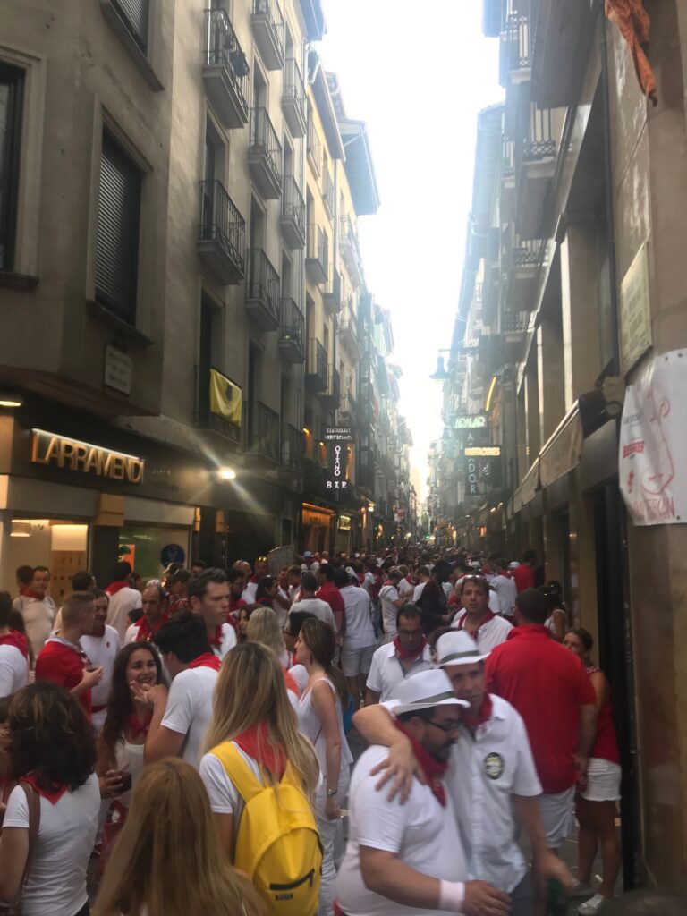 People dressed in all white with red buffs fill the streets in the evening of La Fiesta de San Fermin. 