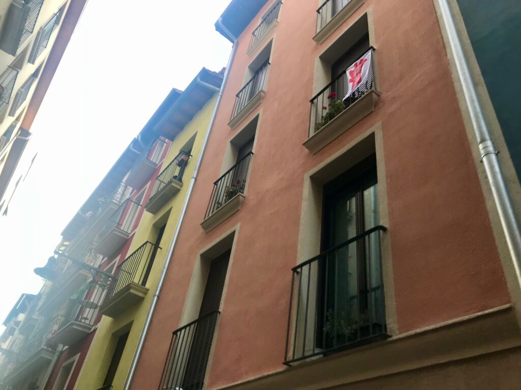 The balconies of Pamplona hang red and white banners in honor of la Fiesta de San Fermín. 